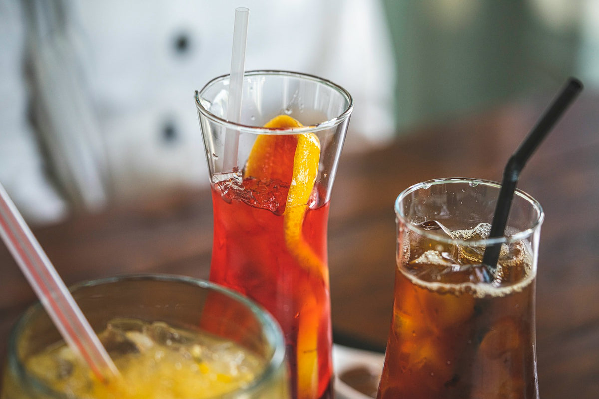 Assorted iced drinks with straws and slices