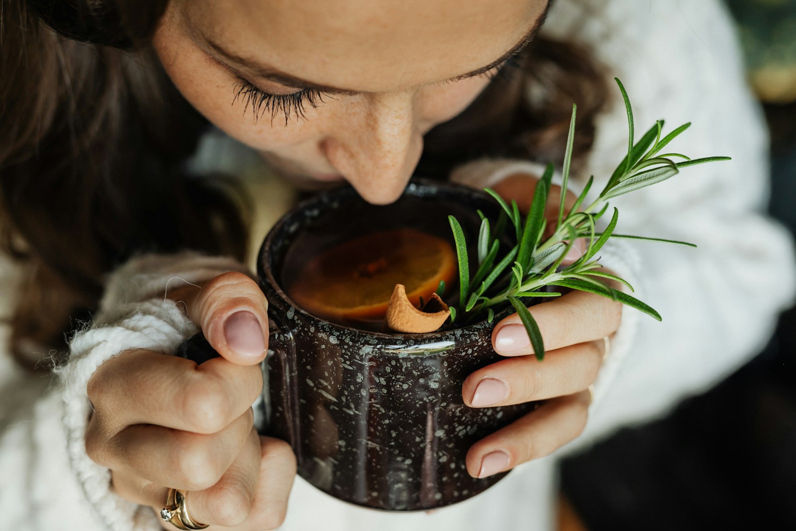 Woman enjoying herbal tea with rosemary