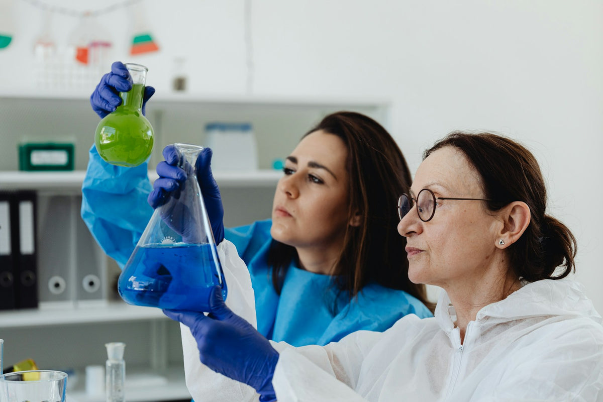 Scientists examining colored chemical solutions