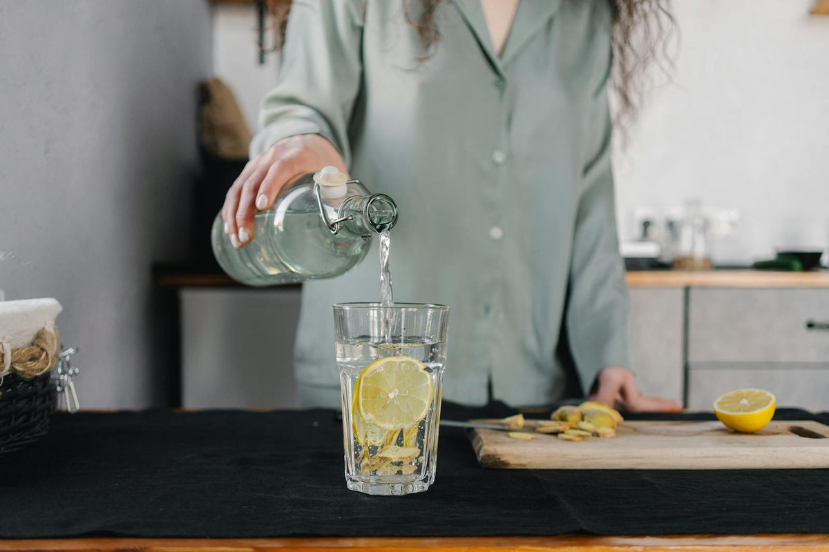 Pouring lemon water into glass pitcher
