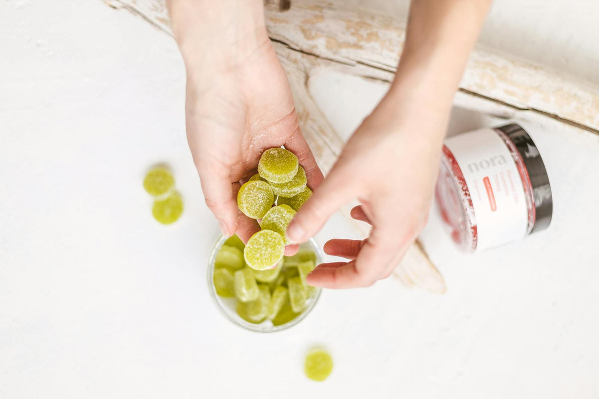Hands holding green gummy candies