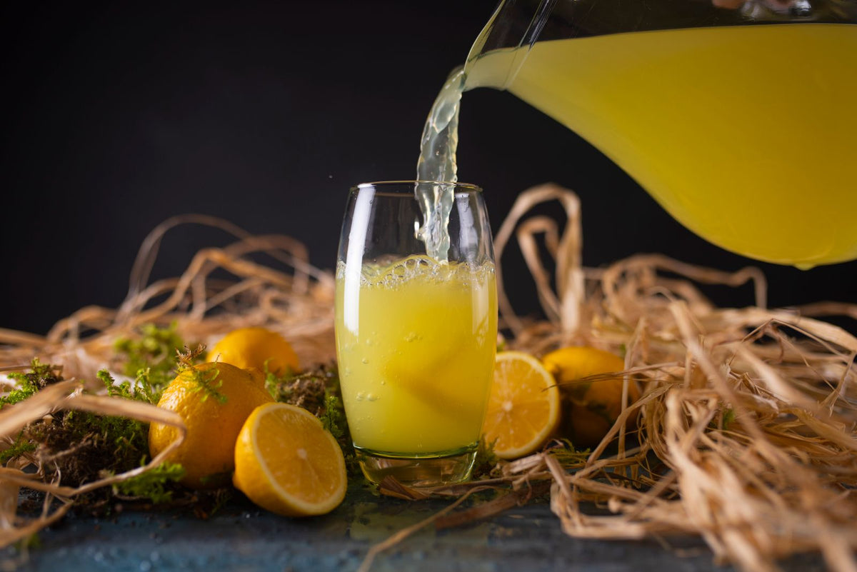 Pouring fresh lemon juice in glass