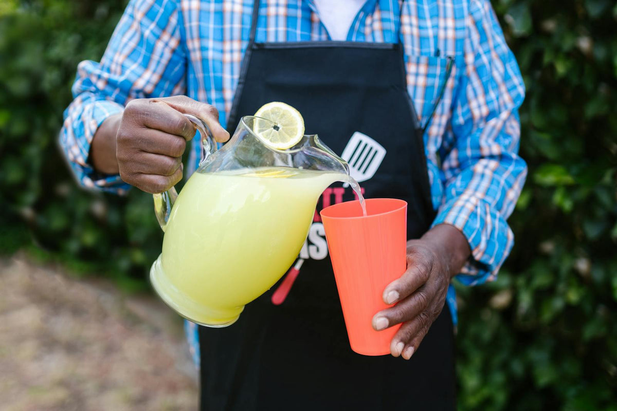 Pouring fresh lemonade outdoors in summer