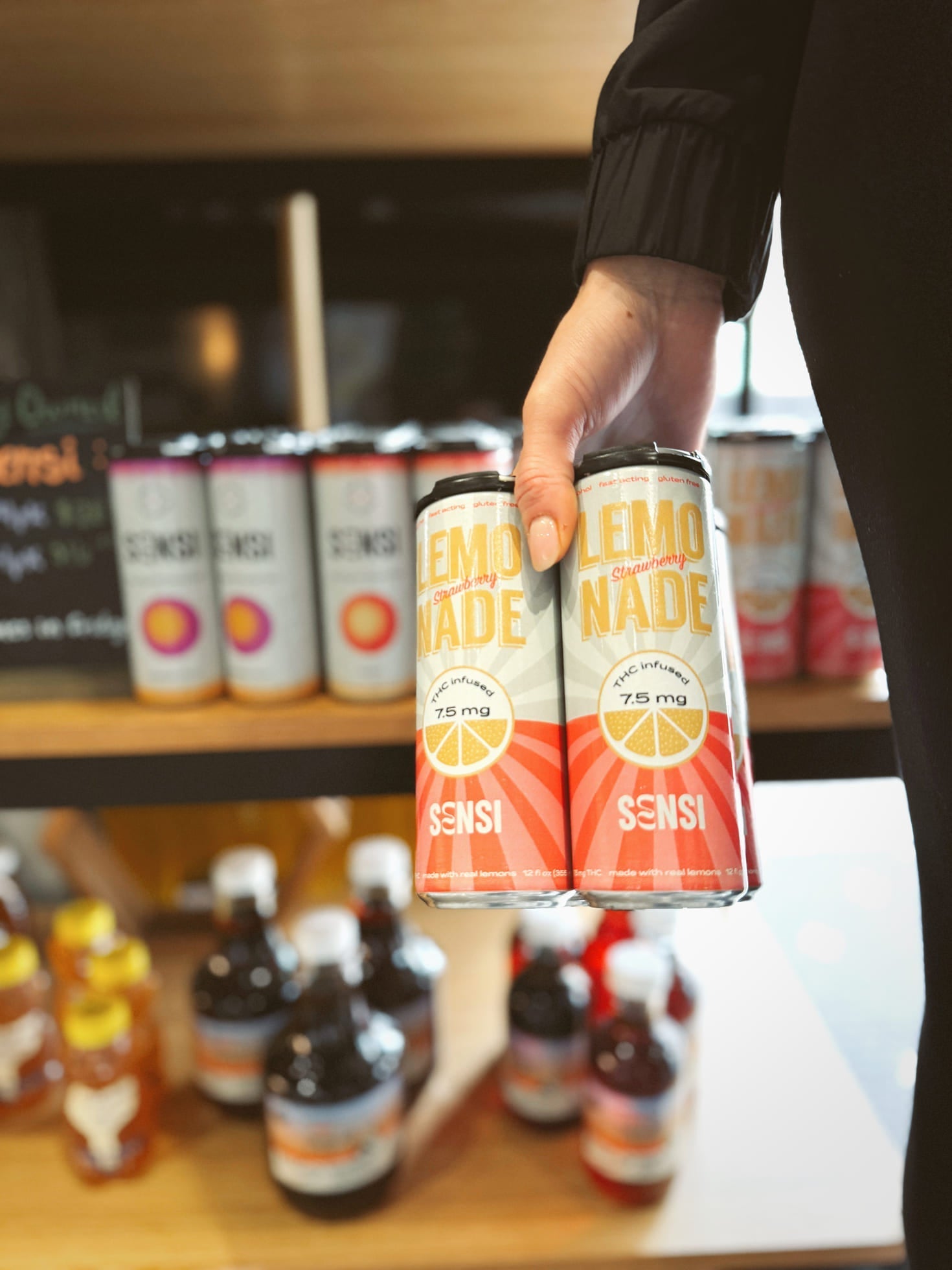 Hand holding Lemonade cans in store display