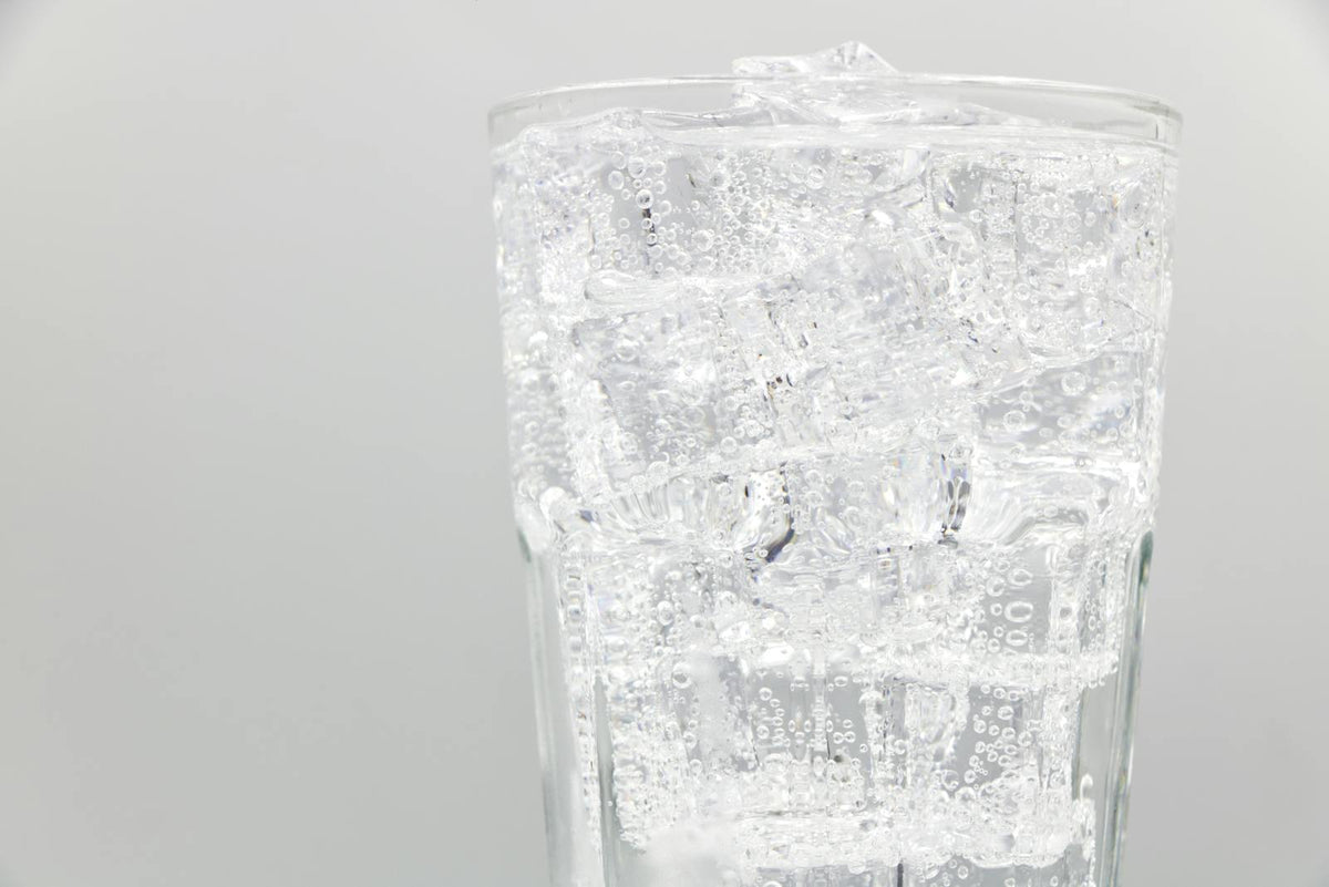 Glass of sparkling water with ice cubes