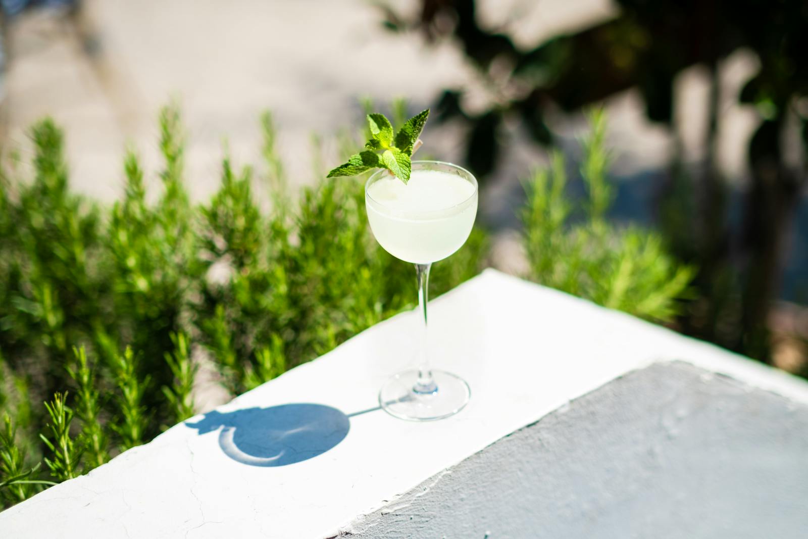 Refreshing cocktail with mint on white table