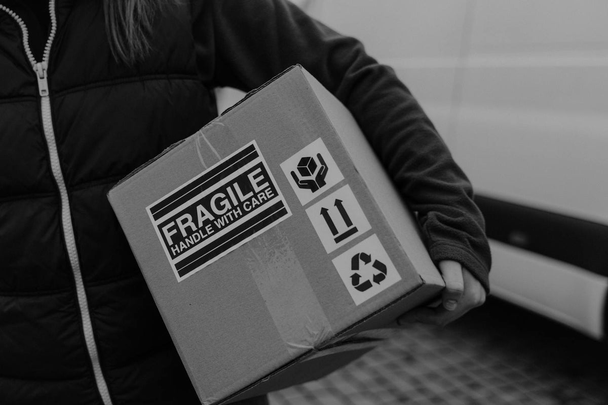 Person carrying fragile labeled package