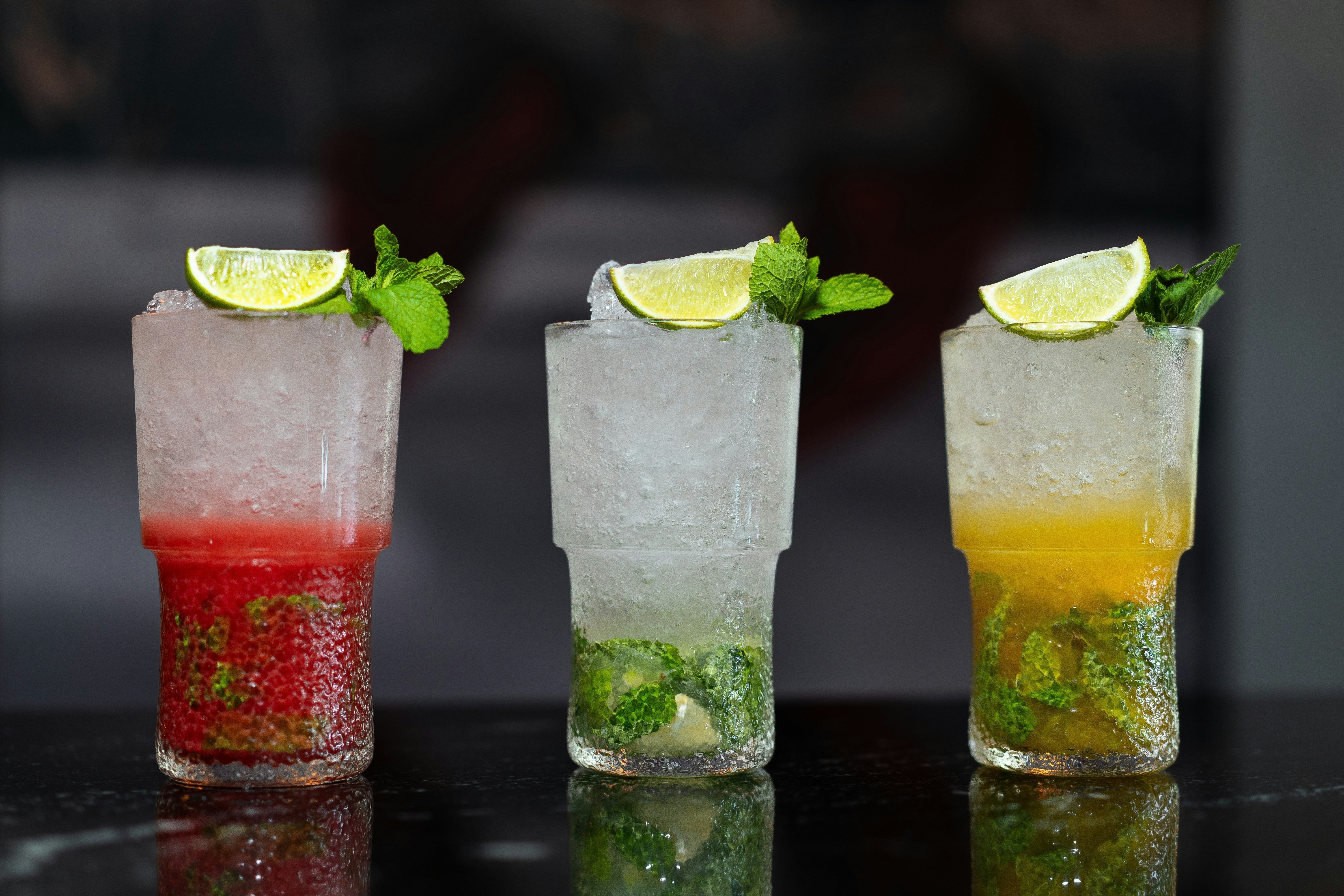 Colorful cocktails with lime and mint garnish