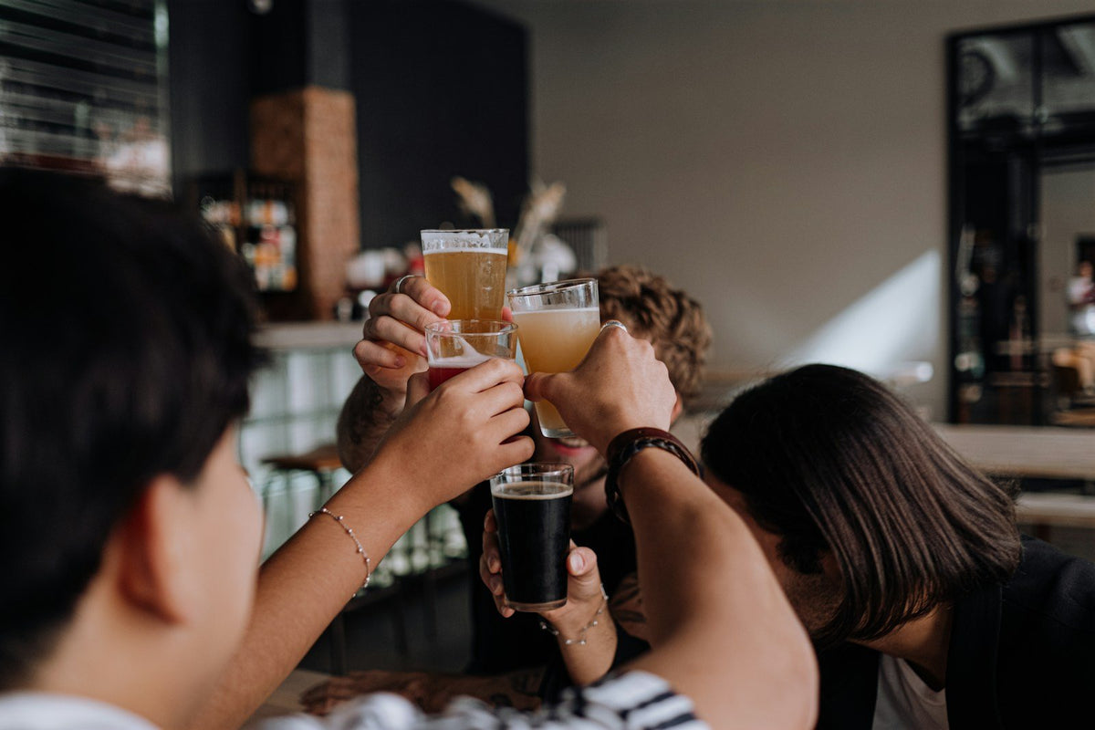 People toasting with craft beer glasses