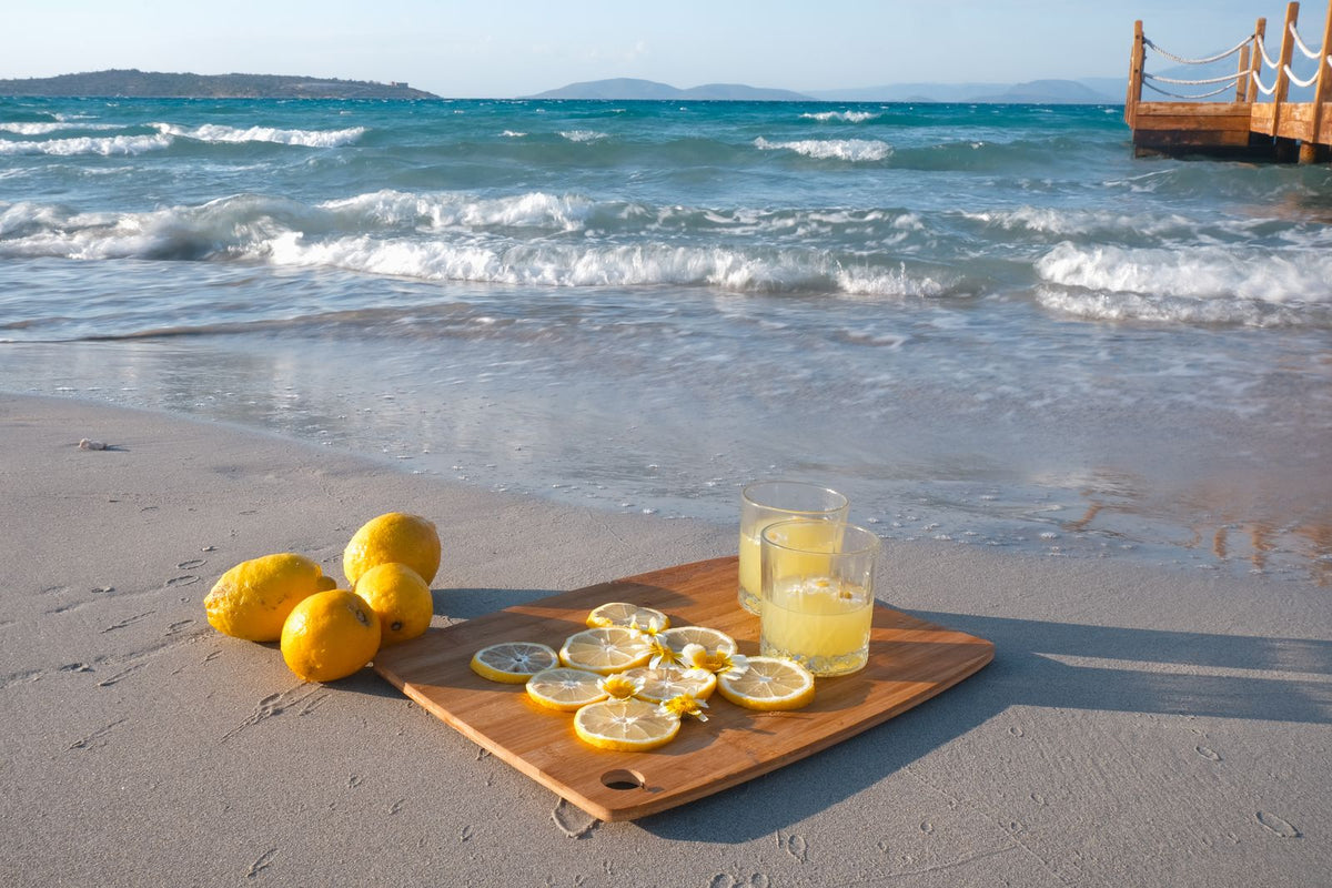 Fresh lemonade with lemons on beach shore