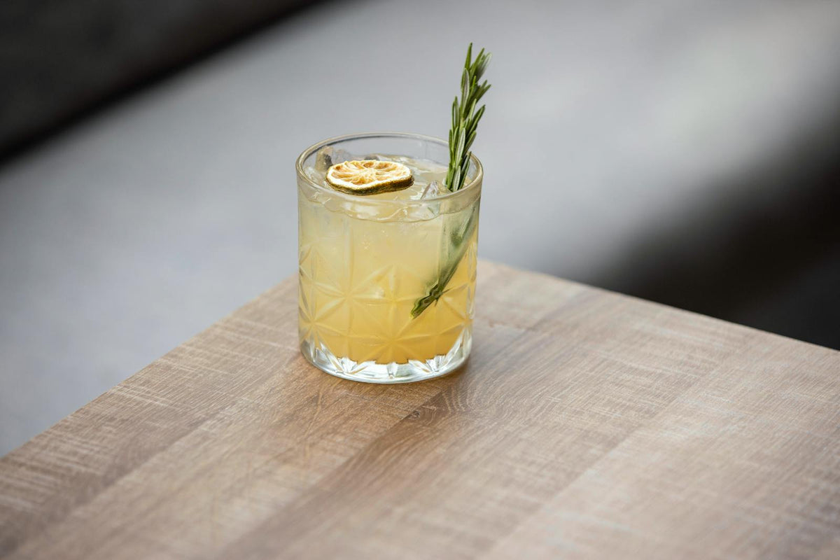 Refreshing cocktail with rosemary and citrus garnish