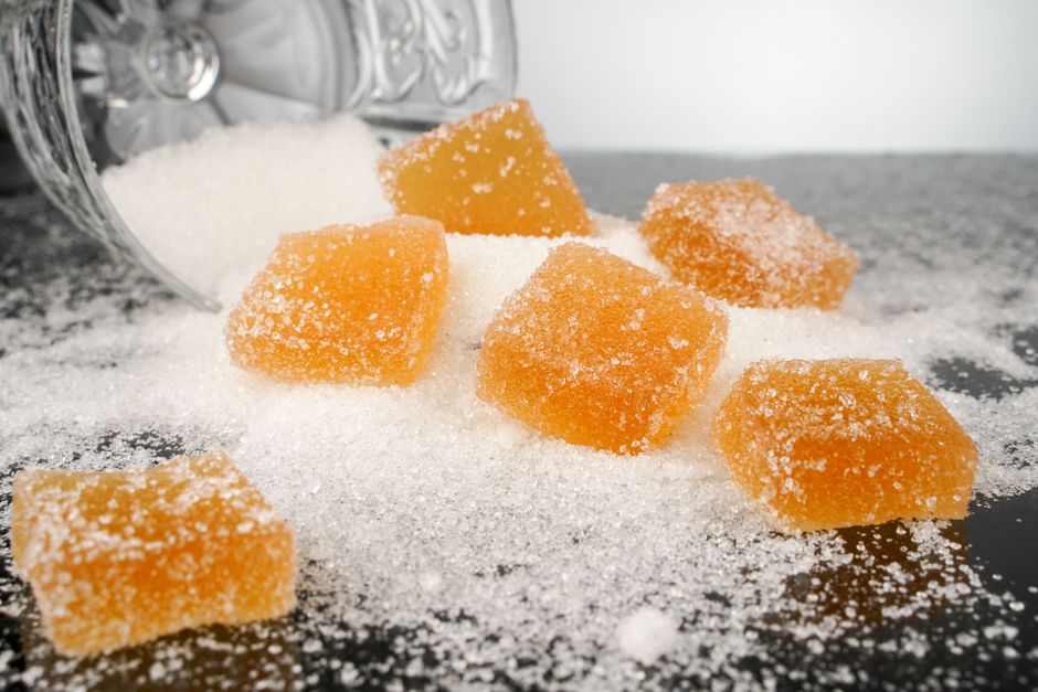 Orange jelly candies on spilled sugar