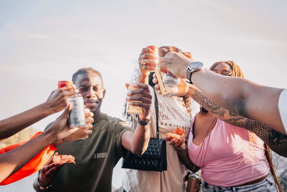 Group of friends raising drinks and food together