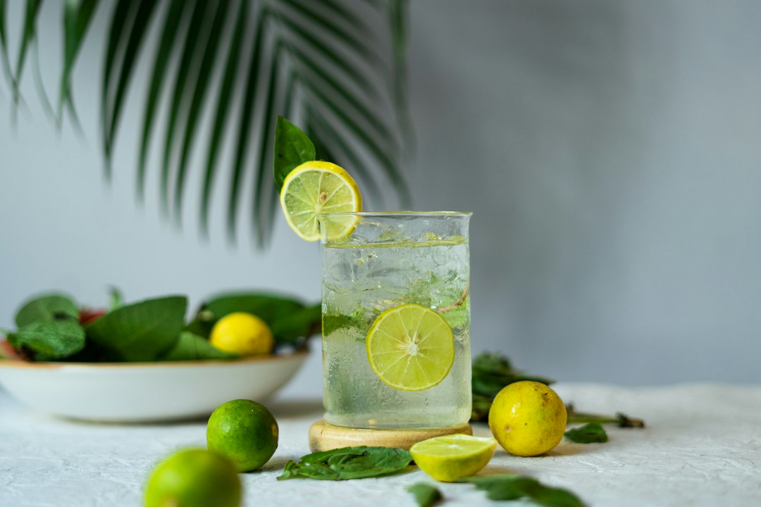 Glass of lemon mint drink with ice and sliced lemons