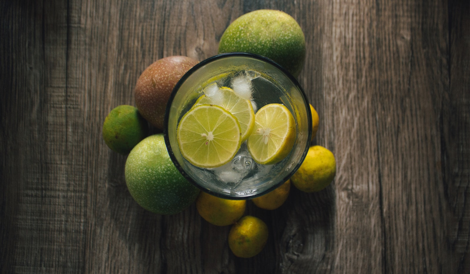 Lemon water with assorted fruits rustic background