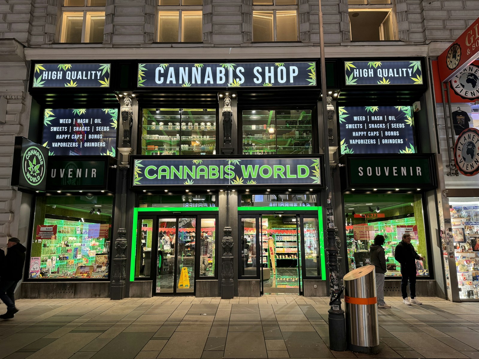 Cannabis shop exterior at night, colorful signage