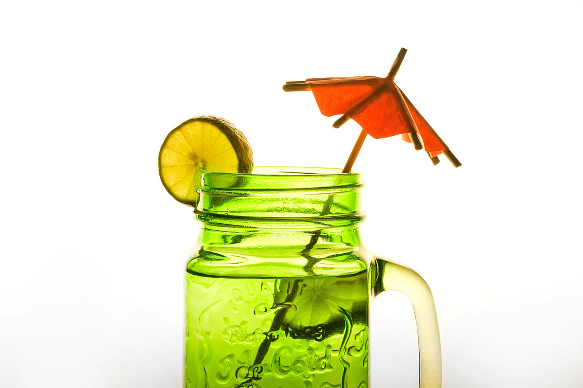 Green mason jar with lemon and umbrella